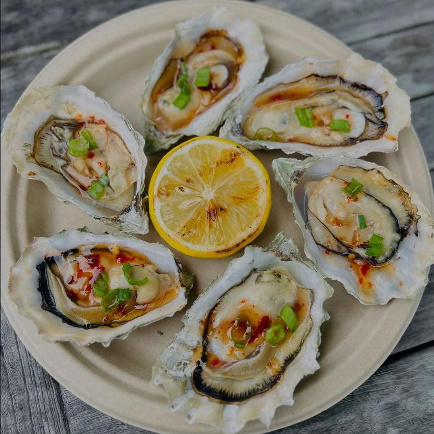 Plate of BBQ Hog Island oysters with grilled lemon