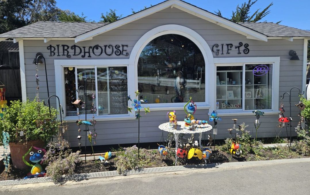 Birdhouse Gifts storefront with colorful garden art out front